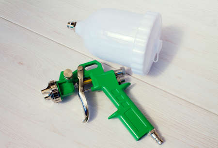 Green air compressor gun. Isolated on a wooden background. Industrial conceptの写真素材