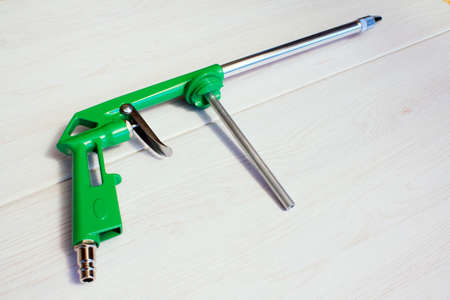 Green air compressor gun. Isolated on a wooden background. Industrial conceptの写真素材
