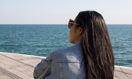 Asian young lady sittinf and enjoying the sea view. Amazing view of seaの写真素材