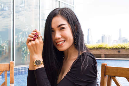 Young Asian Girl sitting in front of the pool. Can be use as concept photoの写真素材