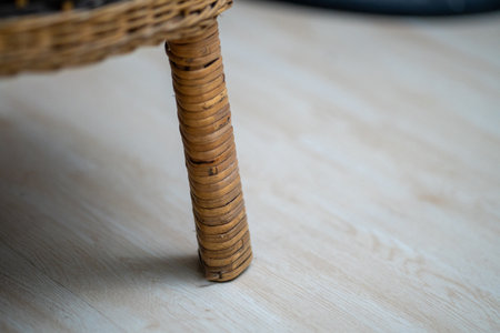 Brown rattan wooden chair leg on wooden floor close upの写真素材