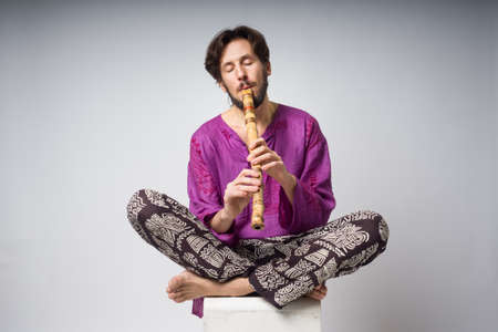 The musician who plays ethnic instruments.  The man sitting in the lotus position plays the flute. The young man in the national Indian clothesの写真素材