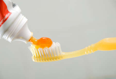 Yellow toothbrush with pastegel and a tube