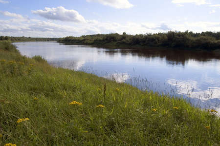 The river with reflection of clouds and the blue sky