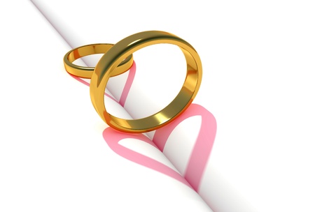 Gold love rings, heart shadow on a book middleの写真素材