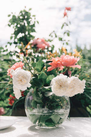 Brides wedding shoes with a bouquet with roses and other flowers on tha arm chairの写真素材