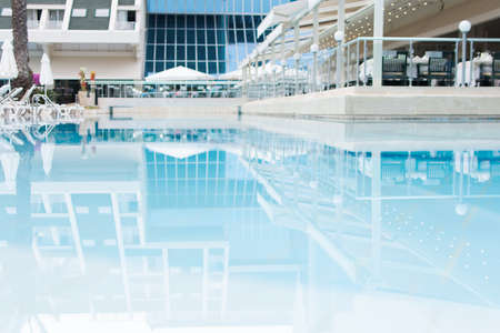 Relaxing rattan chairs with pillows beside swimming poolの写真素材