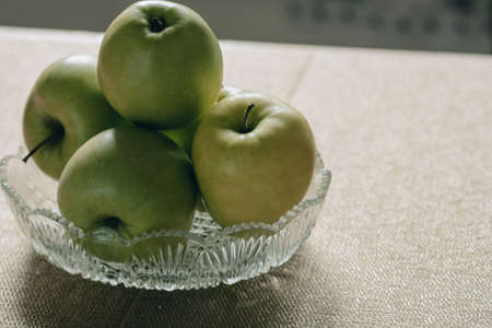 Glass vase with green apples.Fresh juicy fruits, vegetarian food.の写真素材