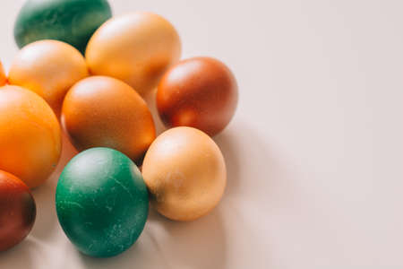 Small multi-colored Easter eggs on the kulich, festively decorated with colorful painted eggs paint, backgroundの写真素材