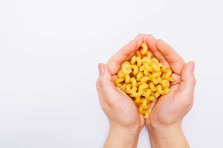 Pasta in female hands. Hands holding macaroni. Nice
