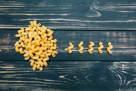 On a black wooden background macaroni. A bunch of pasta. Niceの写真素材