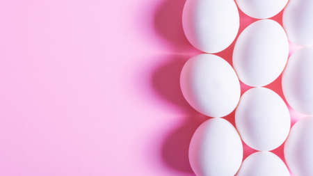 White egg on pink background. minimal concept. top view.の写真素材