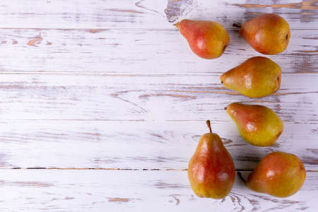 Ripe pears on a wooden table are collected in a groupの写真素材