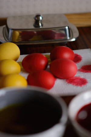 Painted eggs dry after painting on a paper napkin. Freshly baked homemade Easter bread, natural dyed eggs and spring flowers. Happy Easter. Stylish paska with sugar glaze and sprinkles, a traditional Ukrainian bun.の写真素材