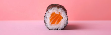 A single piece of sushi resting on a bright pink surface.の素材