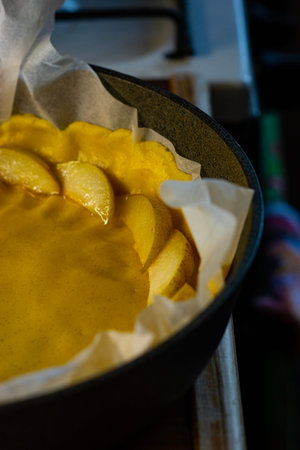 Golden fruit pie with delicate slices arranged over a rich yellow filling, nestled in parchment paper.の写真素材