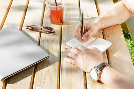 The young man writes in his notebookの写真素材