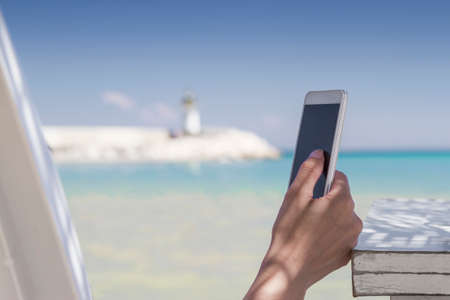 Woman using her smartphone at the beachの写真素材