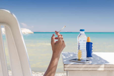 Woman smoking at the beachの写真素材