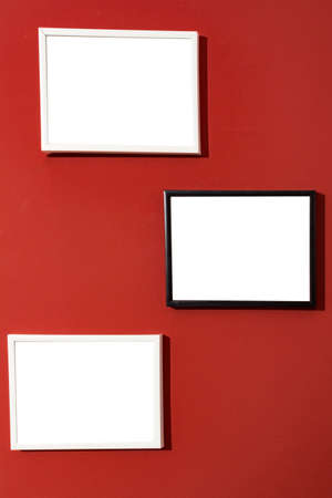 Black and white photo picture frames isolated white, blank painting frames on red wall. Mock Up.の写真素材