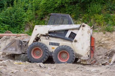 A close up of a white bobcat s550 or skid loader on construction siteの写真素材