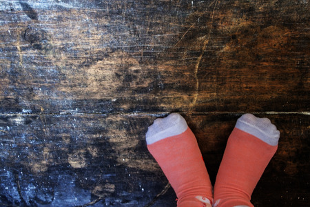 Girl Wear Pink Socks Standing in Corner Of Old Black Wood and Make Love Shapeの写真素材