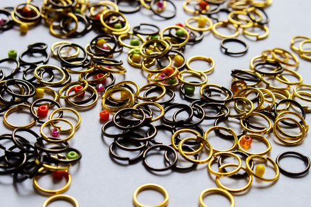 Close up of Gold and Bronze Color Jumpring Use For Jewelry With Colorfull Seed Beads on White Backgroundの写真素材