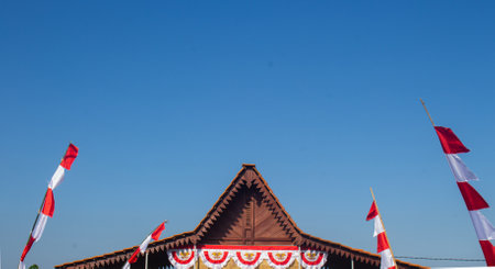 traditional Indonesian building decorated with red and white flags, showcasing national pride and cultural celebration, perfect for cultural, heritage, or event-themed contentの写真素材