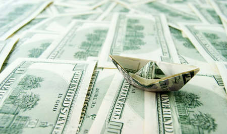 Ship made of dollar note on dollar notes backgroundの写真素材