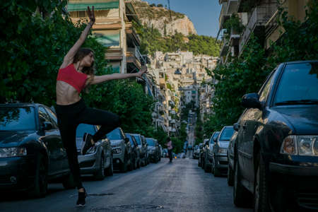A young pretty fitness female dancer is posing on the cityの写真素材