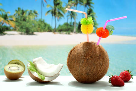 coconut cocktail with fruit on the beachの写真素材