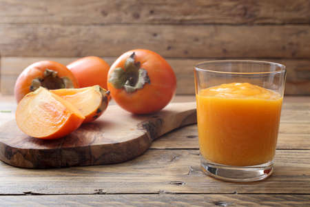 Persimmon fruit and smoothie on rustic table backgroundの写真素材