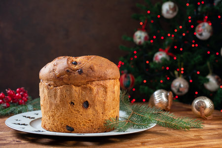 Panettone with raisins and christmas tree on backgroundの写真素材