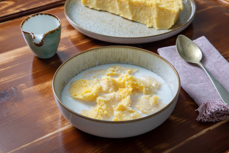 Close up of a bowl of rice pudding with milk on wooden table