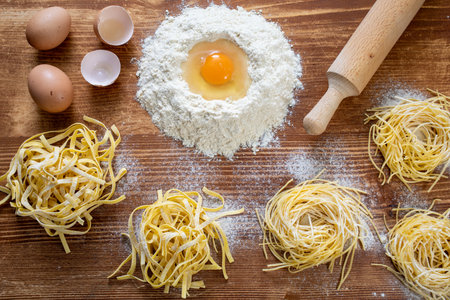 Noodles with flour and eggs on a wooden table. Top viewの写真素材
