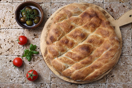 Tasty khachapuri with tomatoes and olives on tableの写真素材