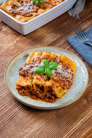 Traditional Italian lasagna with bolognese sauce on wooden backgroundの写真素材