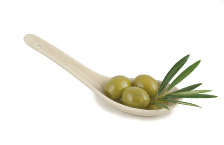Olives in a spoon on a white backgroundの写真素材