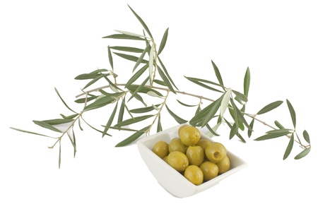 Olives with a branch of an olive tree on a white backgroundの写真素材