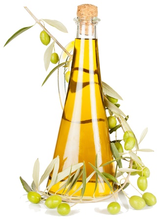 Olive oil in a glass bottle and a branch of an olive tree with fruitsの写真素材