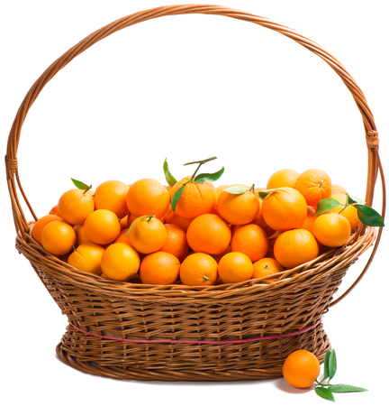 Orange fruits   with leaves in a huge rustic basket isolated on white の写真素材
