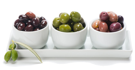 Assortment of olives in a white  bowls  isolated on whiteの写真素材