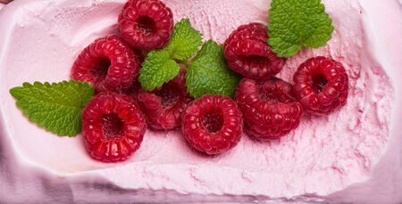 surface texture of scoop of raspberry ice cream with  mint and berries, top viw