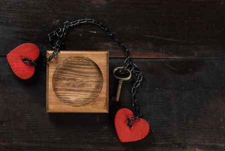 Blank photo frame, key and heart shape on dark wood backgroundの写真素材