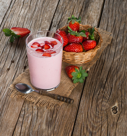 Fresh yogurt in a glass with strawberries on a old rustic wooden tableの写真素材