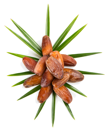 Pile of dried dates on a green leaf of palm isolated on white background, top view.の写真素材