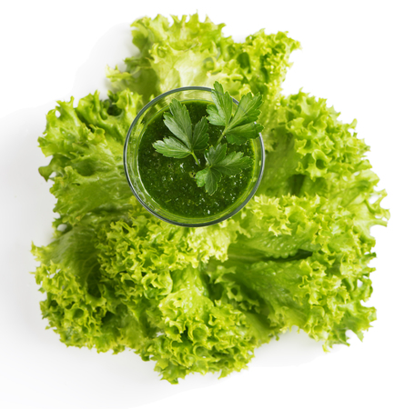 Top view of vegetable green smoothie from leafy kale decorated with parsley in a glas isolated on white backgroundの写真素材