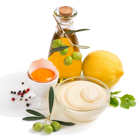 Mayonnaise with ingredients including oil, eggs, lemons and spices isolated on white.の写真素材