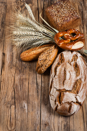 Different bread with ears on old wooden backgroundの写真素材