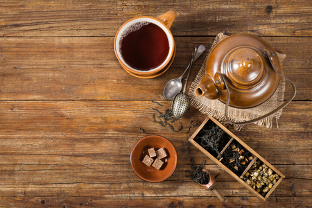 Tea ceremony: various kinds of tea, teapot and tea cup. Top view on a old  wooden table with copy space.の写真素材